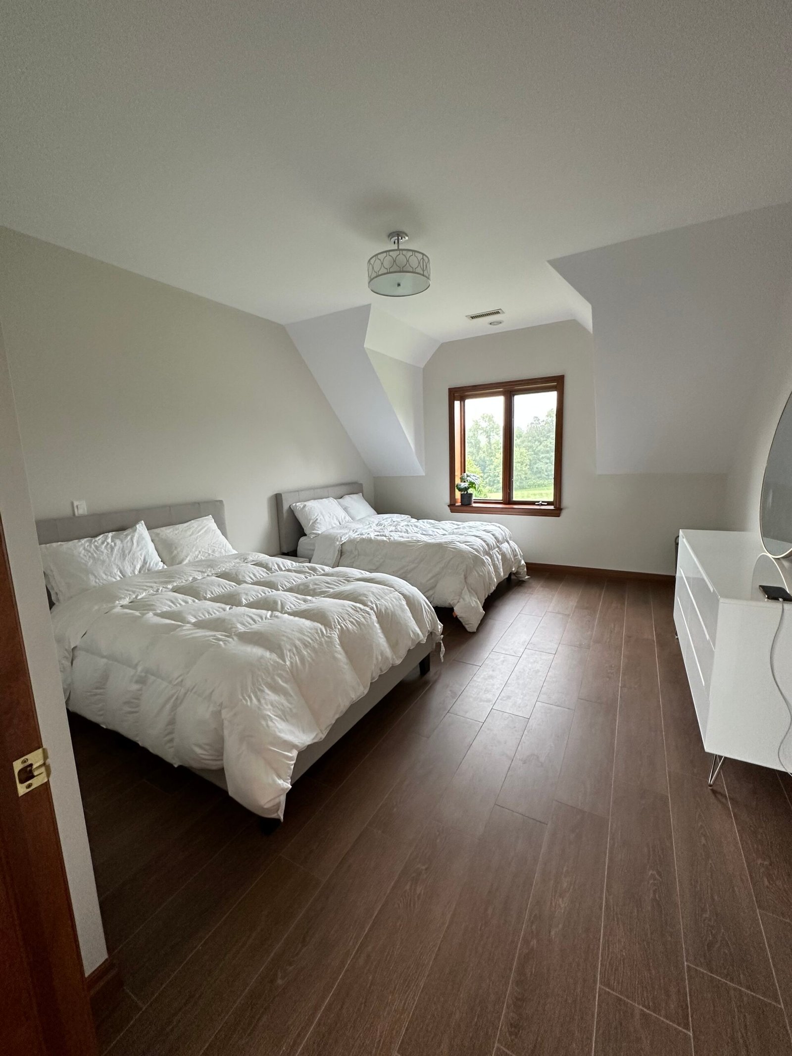 Post-construction cleaning of a bright, spacious double-bed guest room with wood flooring