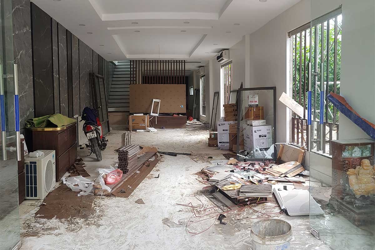 Interior of a building under renovation, with construction materials and scattered debris.