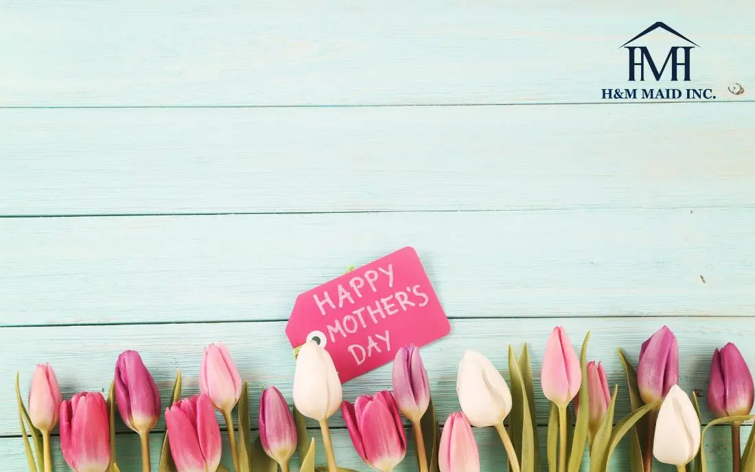 Pink and white tulips with a "Happy Mother's Day" tag on a pastel wooden background, featuring the H&M Maid Inc. logo in the top right.