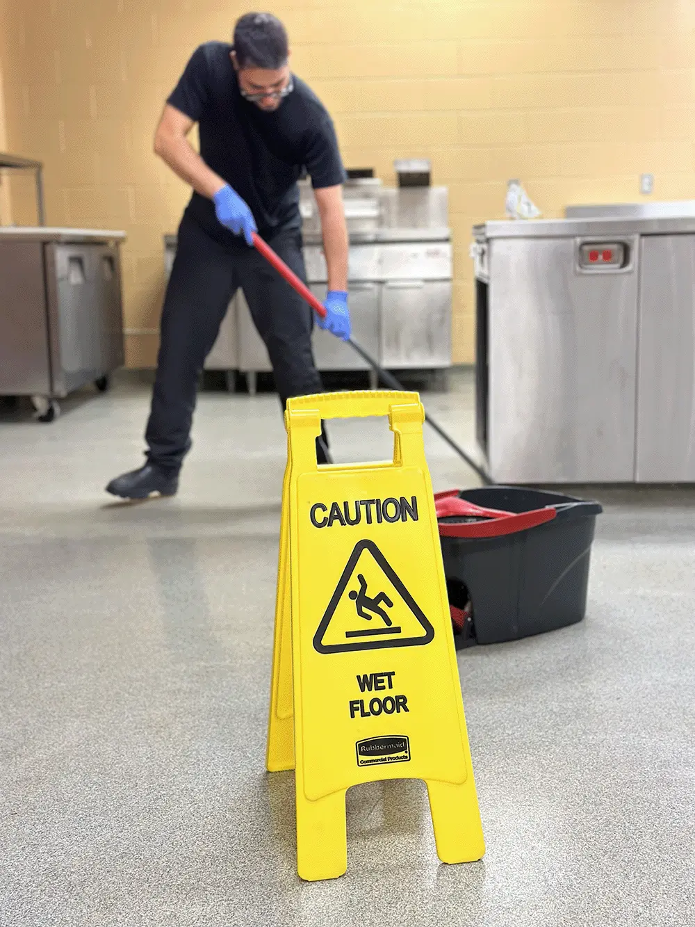 Professional floor cleaning service with mop and caution sign in commercial space